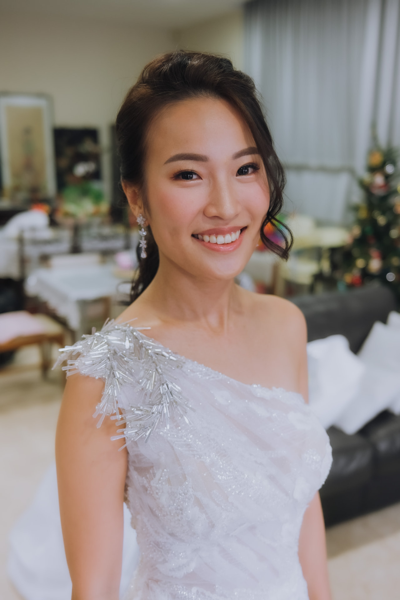 Bride smiling in her one-shoulder beaded gown