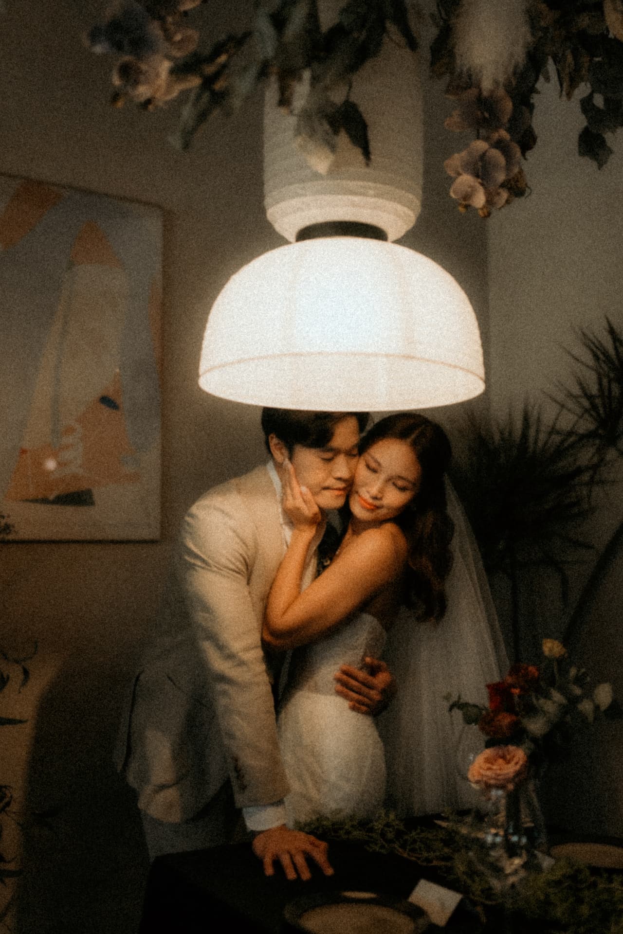 Stacey embracing Benzo beneath the pendant lamp