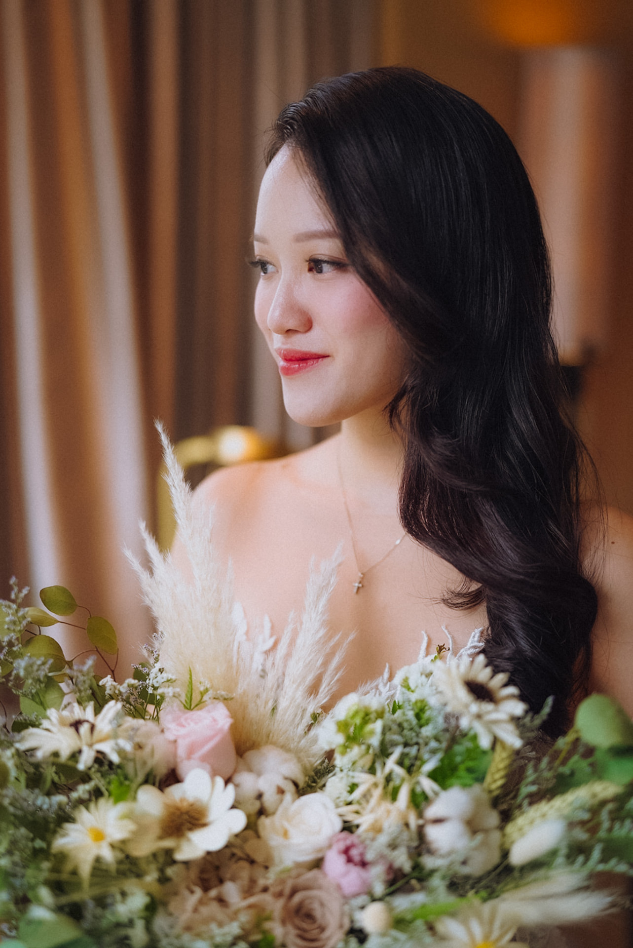 Bride in profile with a pastel bouquet of dried florals