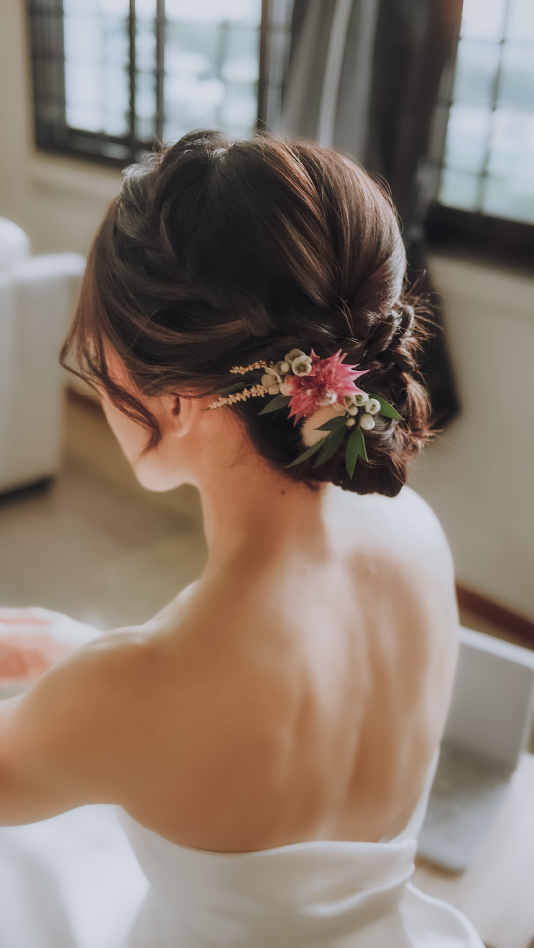 Bride's low updo pinned with dried flowers