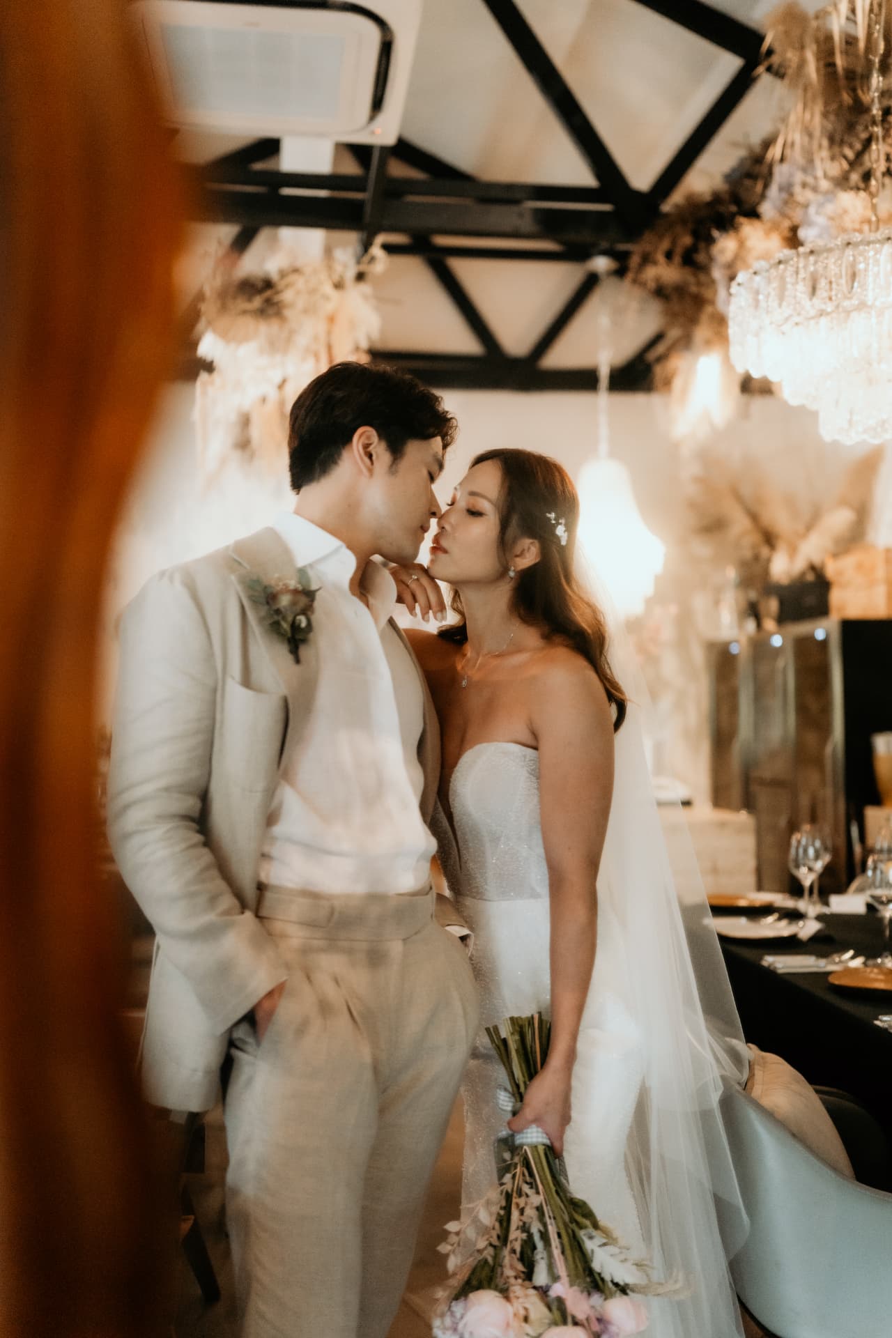 Stacey leaning in close to Benzo holding her bouquet