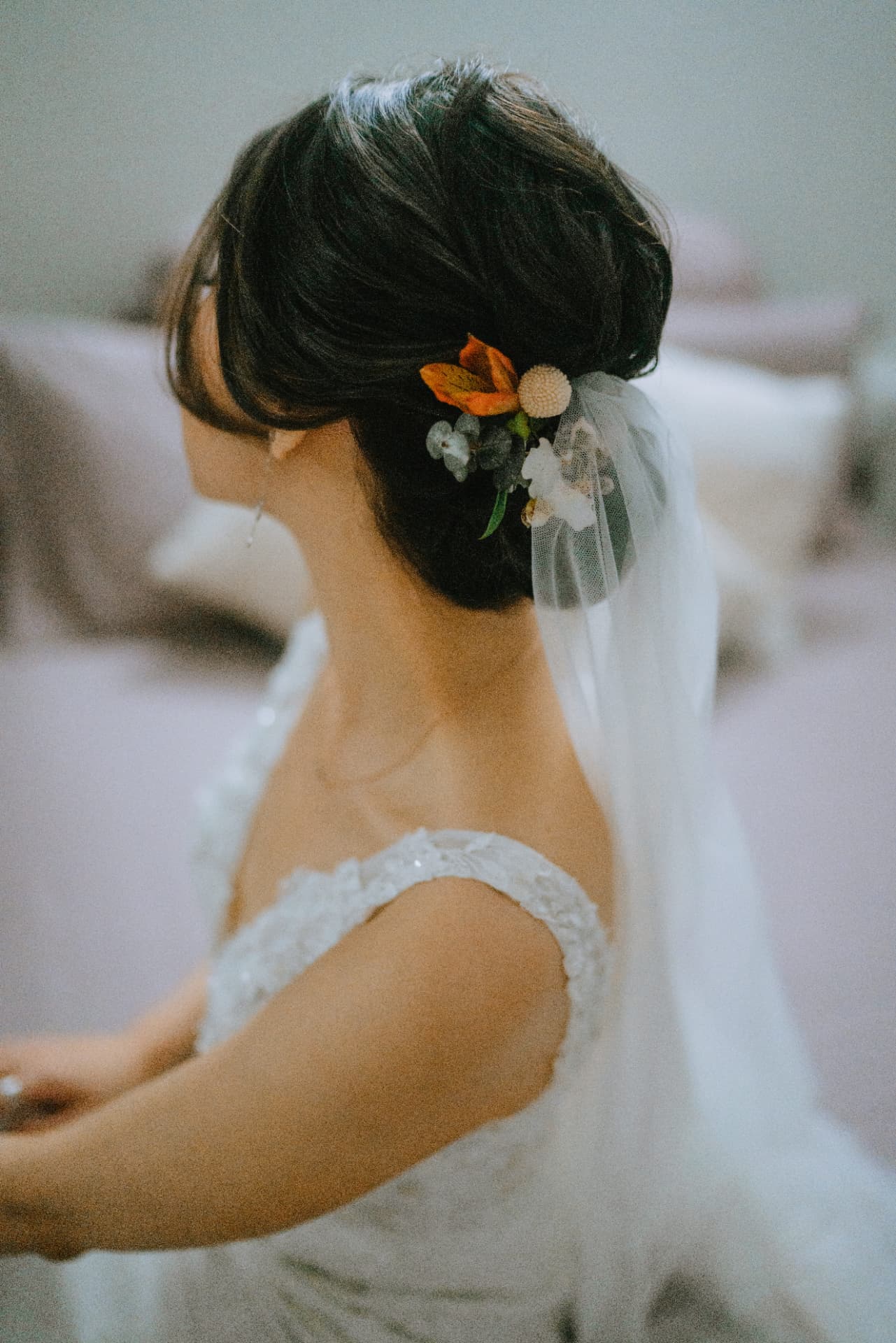 Bride — sculpted low chignon with fresh florals and tulle