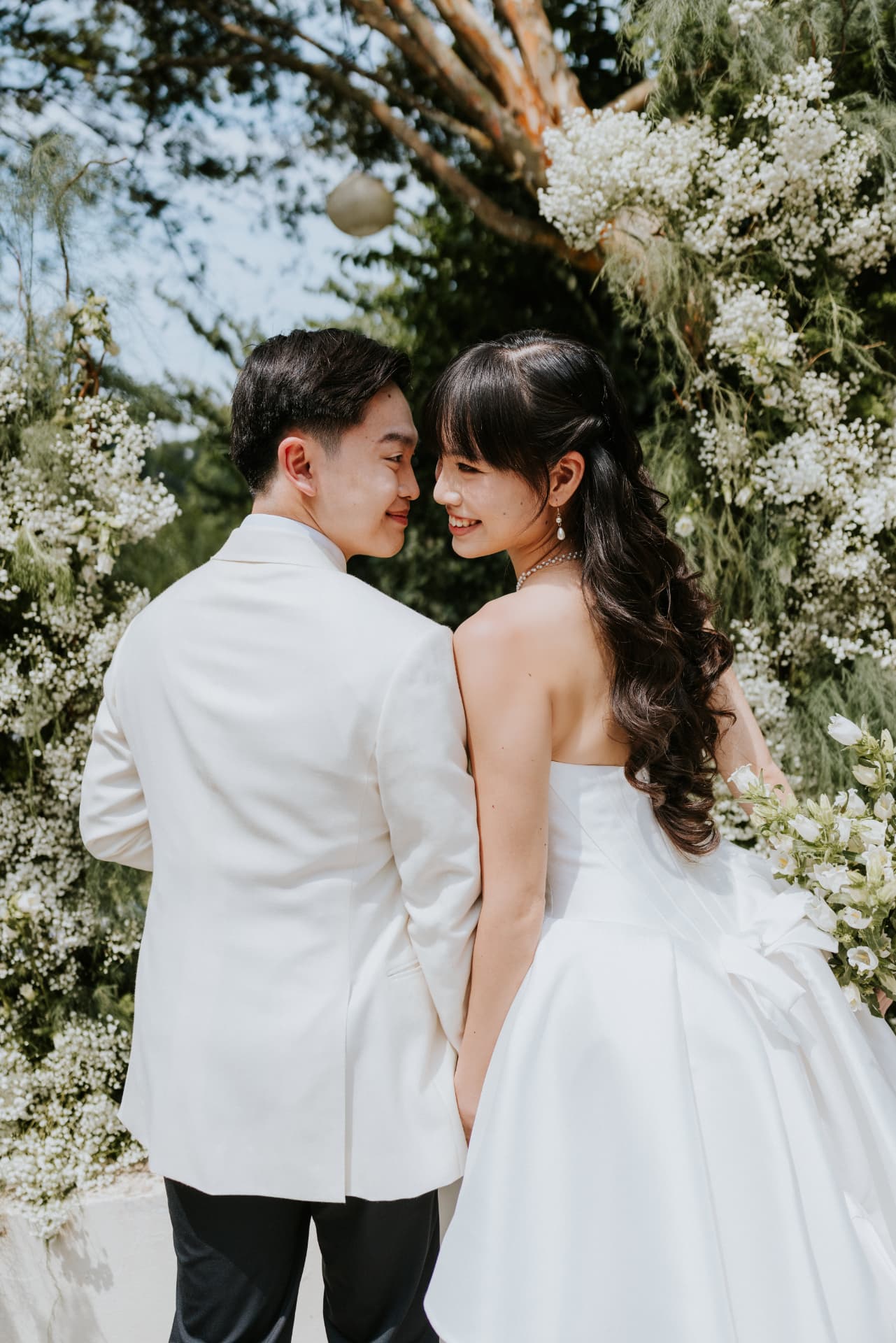Cloud Dancer — the couple smiling back to back, gown with the oversized bow