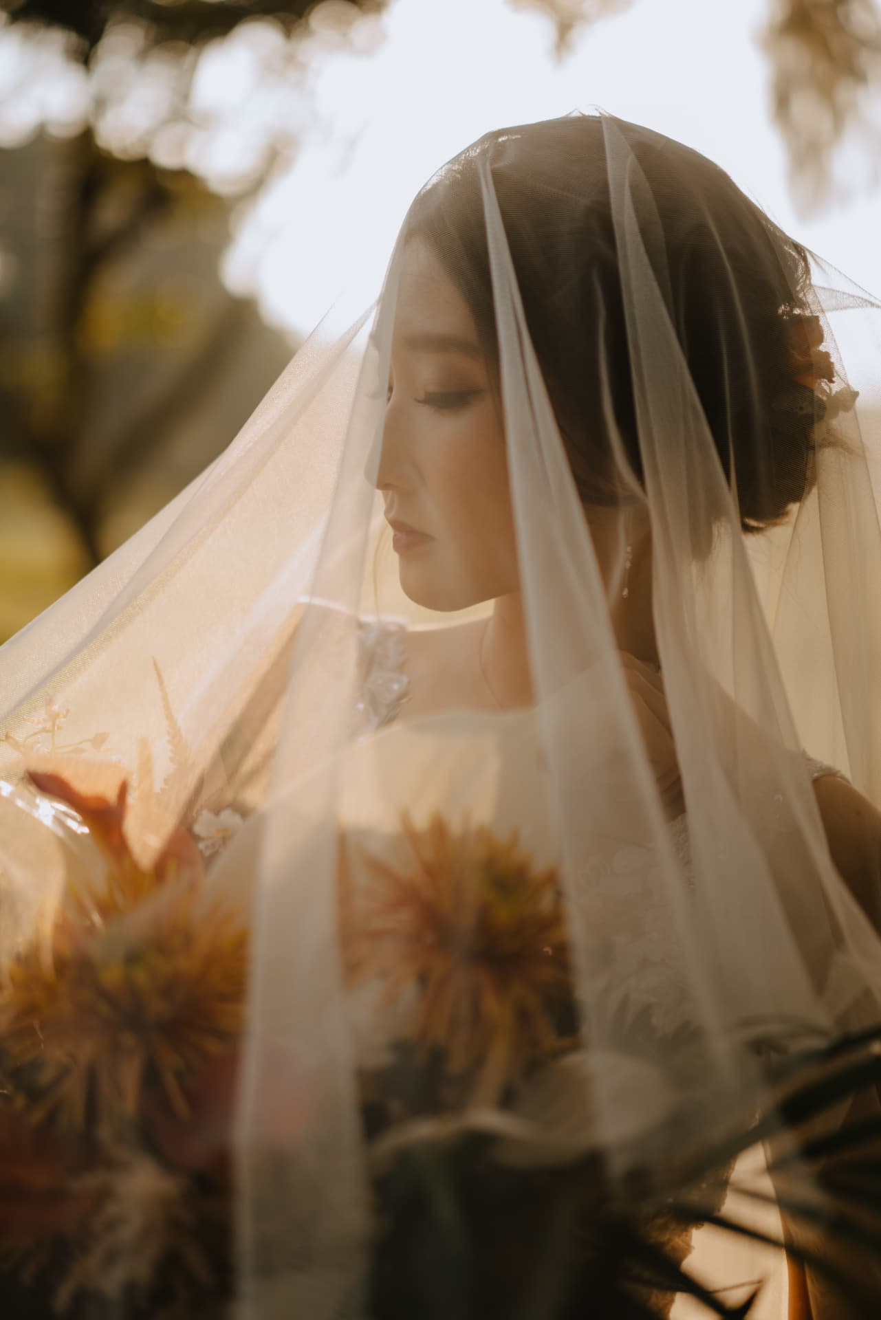 Bride beneath her veil in warm evening light