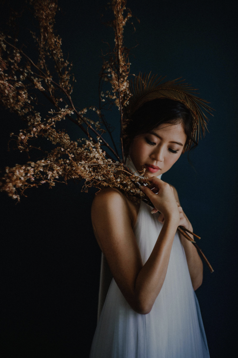 Ophelia — holding dried branches across her shoulder