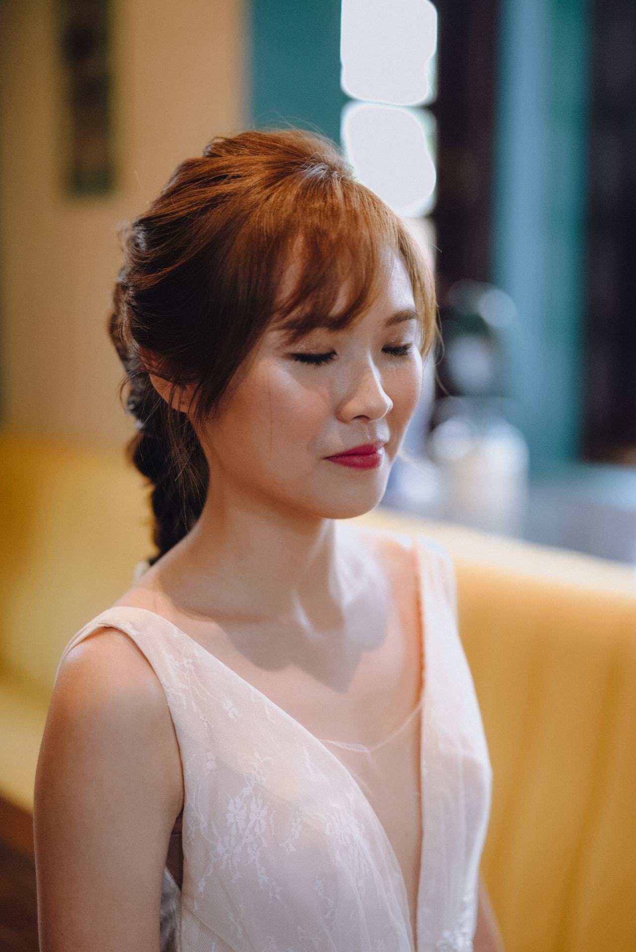 Bride in profile with a braided chignon and red lips