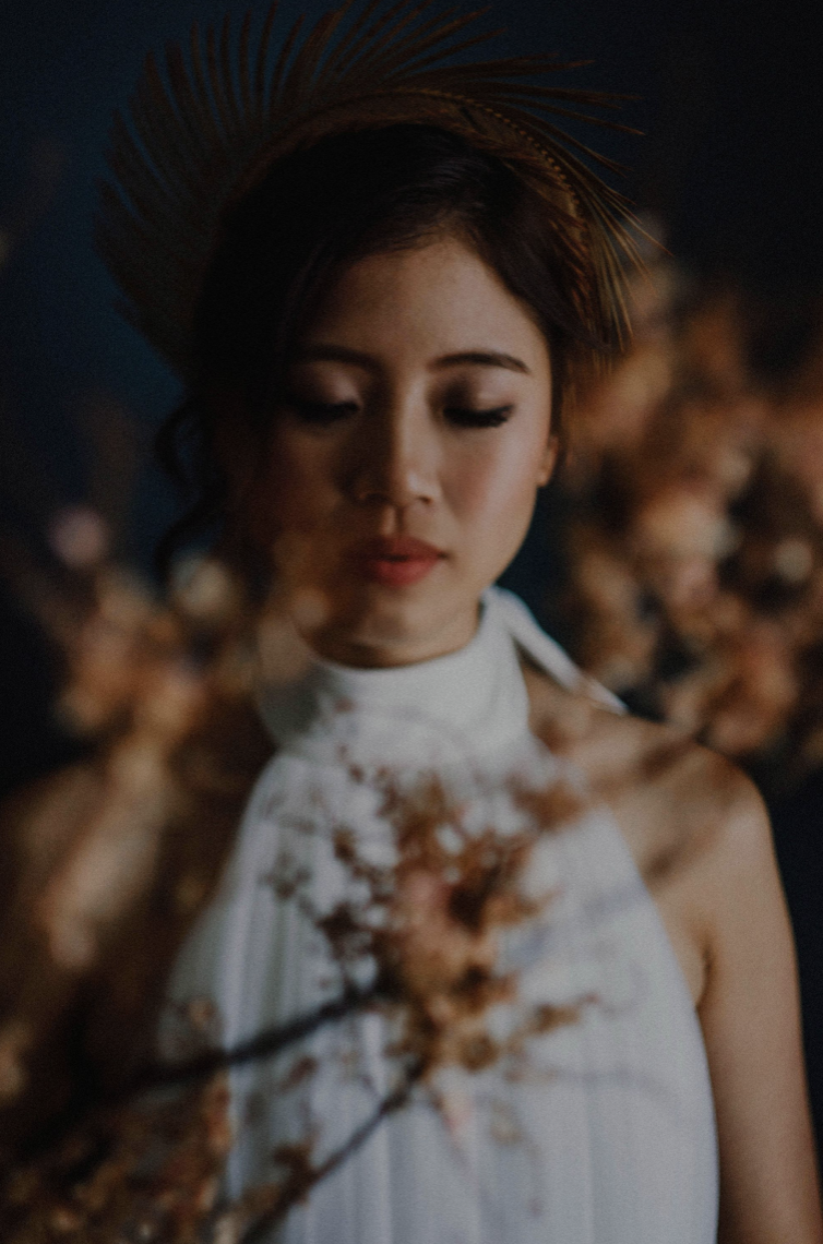 Ophelia — portrait seen through blossom branches, eyes closed