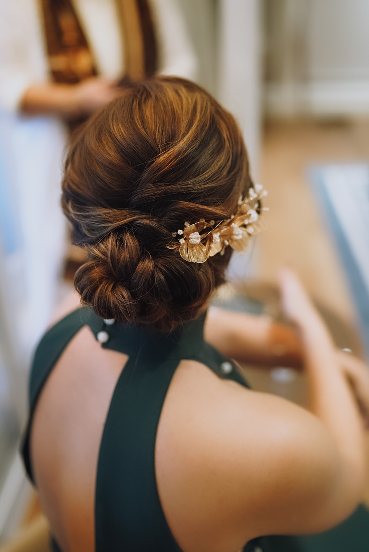 Bride's low chignon pinned with a gold leaf and pearl comb