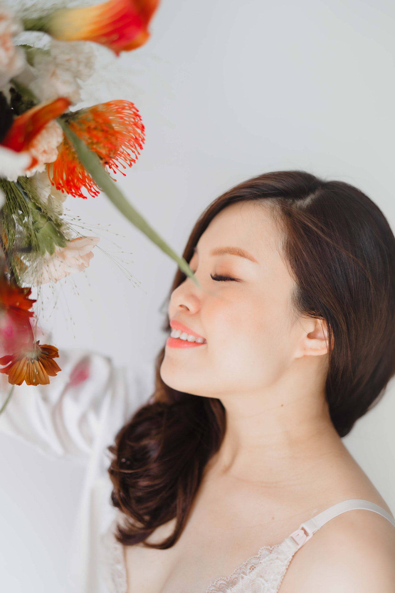 Vivian Ho — eyes closed, smiling beside bright florals