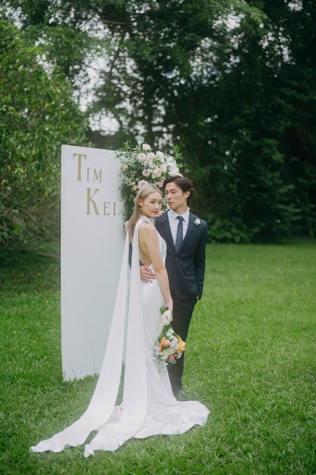 Tim & Denise beside the welcome sign on the lawn