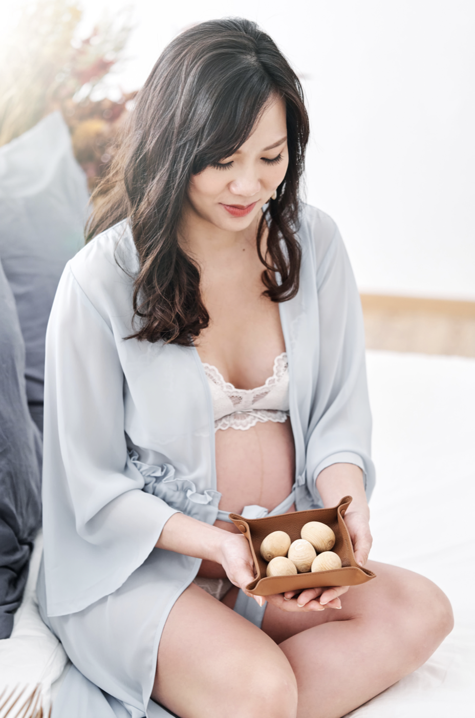 Jillian seated holding a tray of wooden eggs