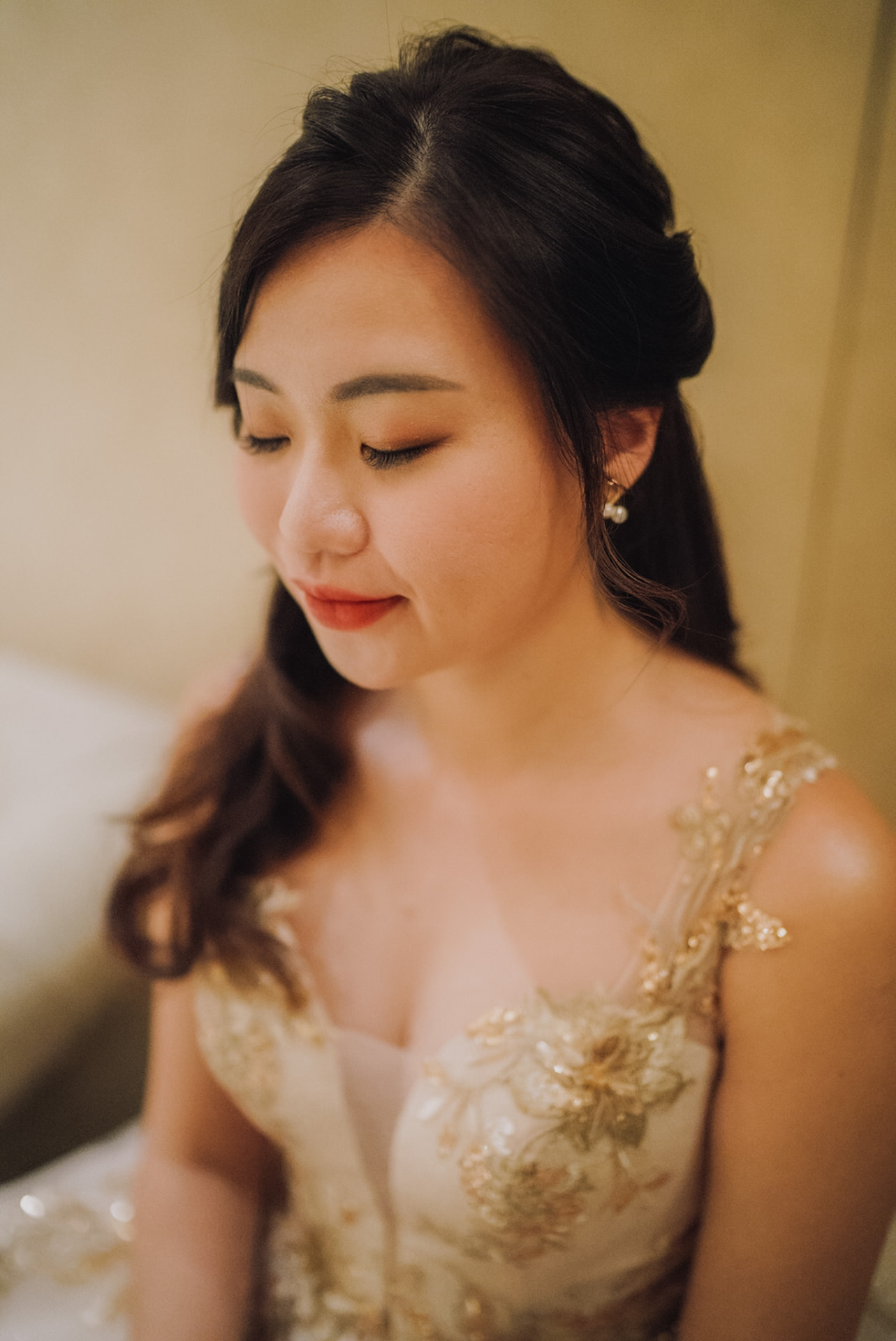 Bride in her gold-embroidered gown, eyes closed