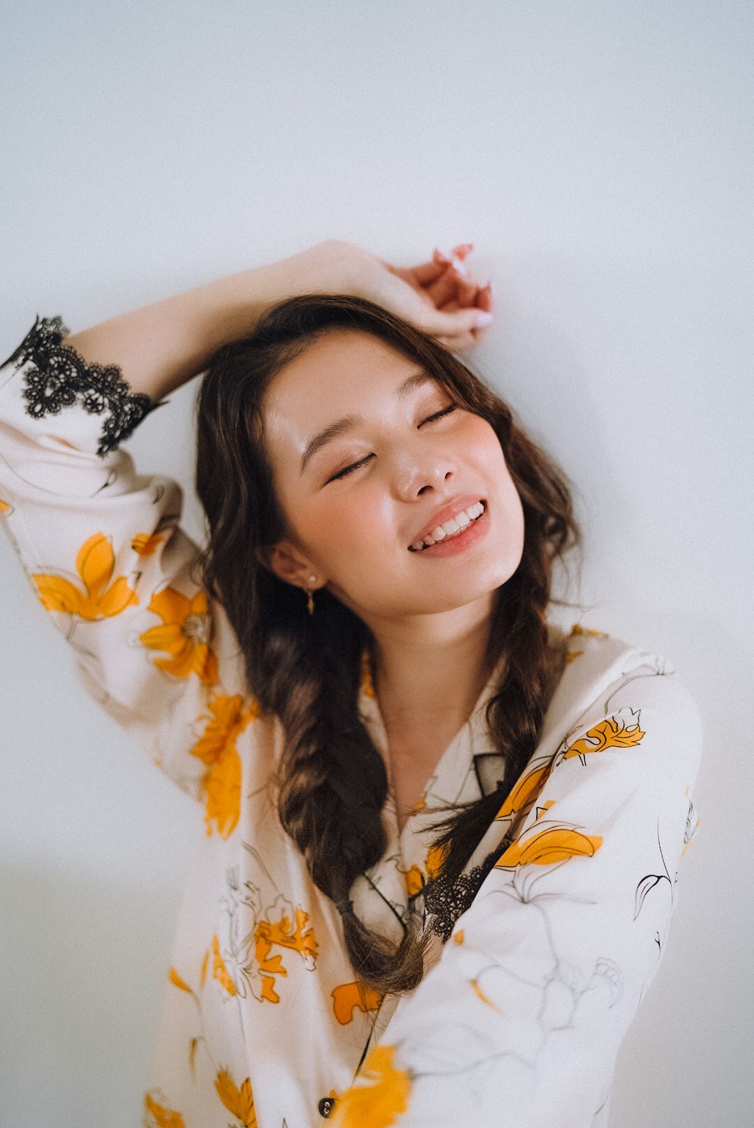 Cala Barrett — smiling with her arm raised overhead, eyes closed