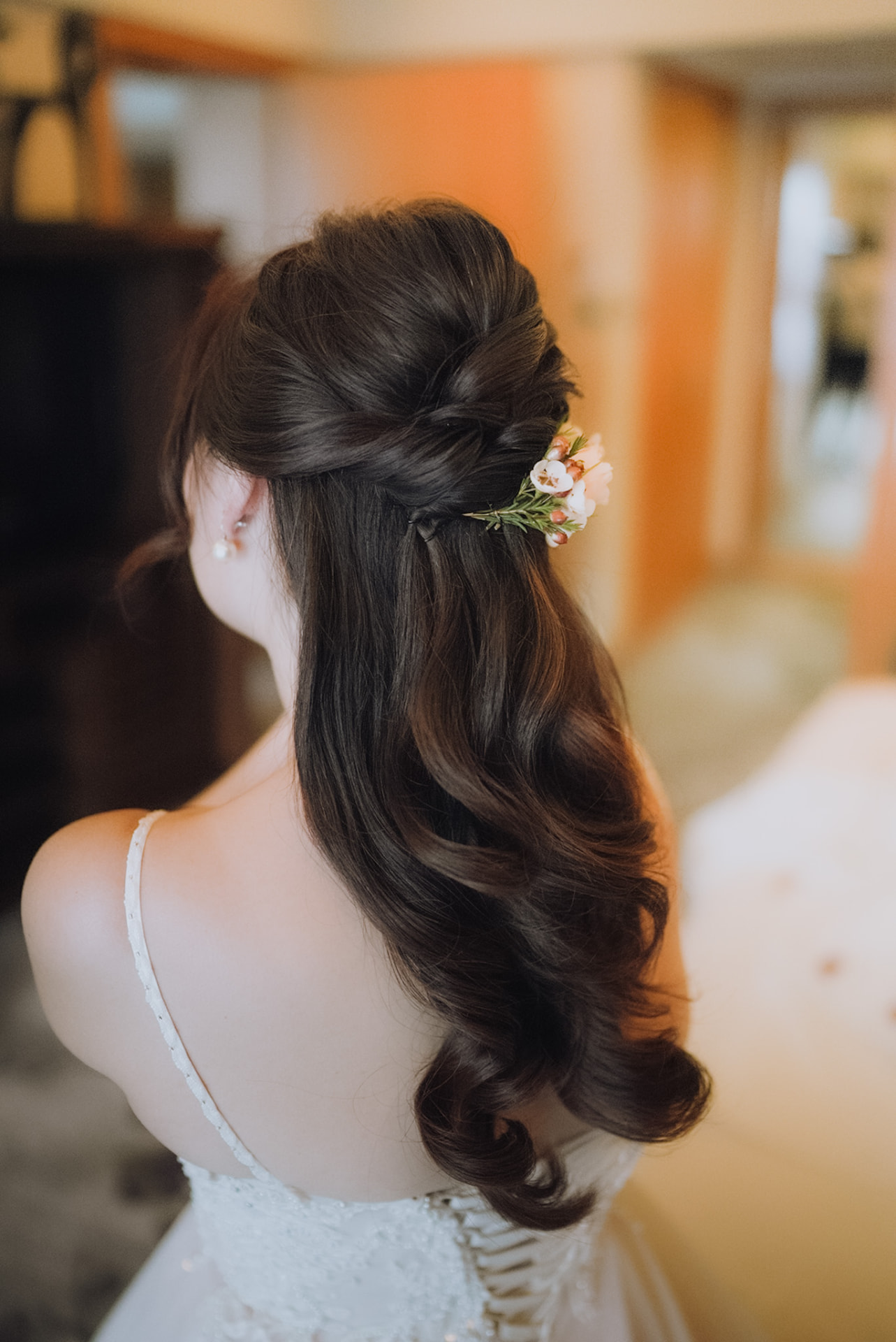 Bride's half-up style with a spray of fresh flowers